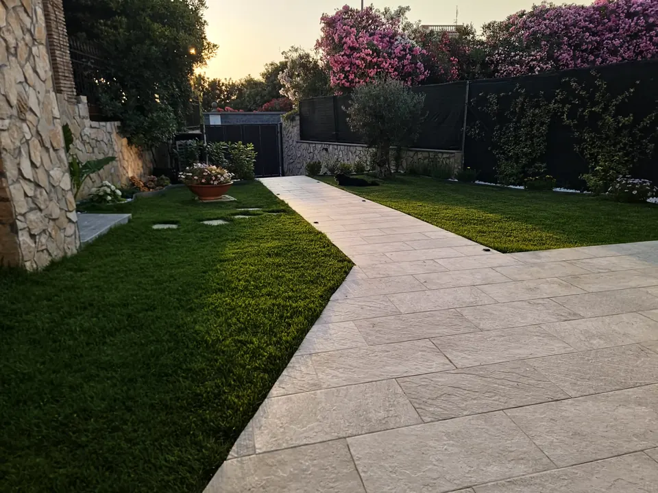 Il vialetto in pietra tra il prato e gli oleandri in fiore