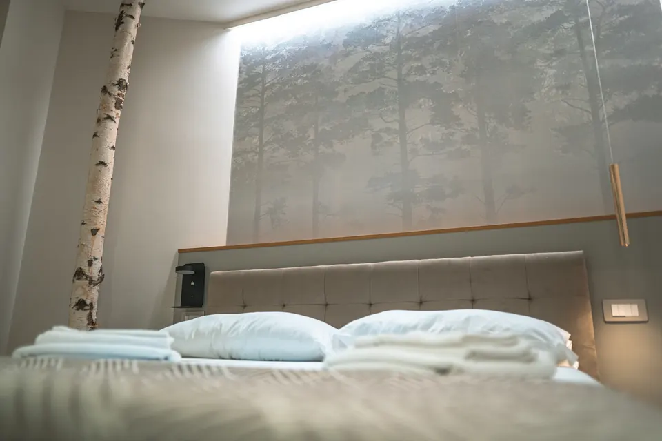 Sakura: il letto con la parete decorata a bosco