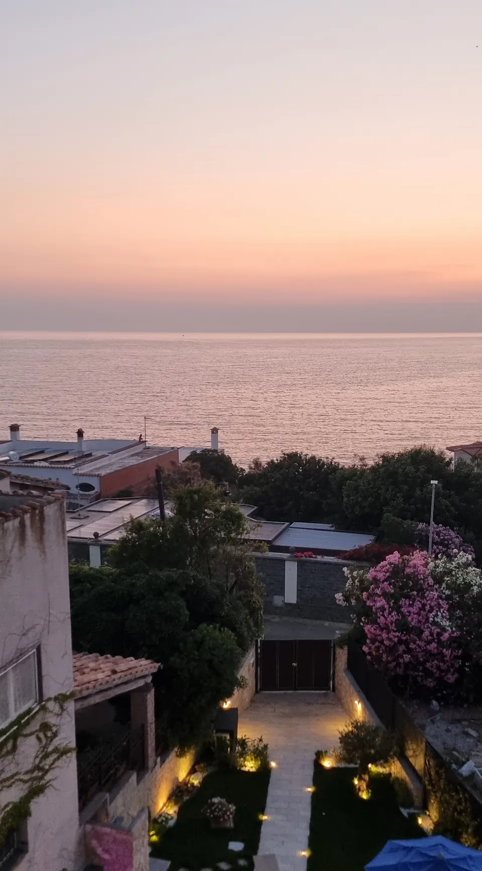 Il giardino illuminato al tramonto, con il mare sullo sfondo